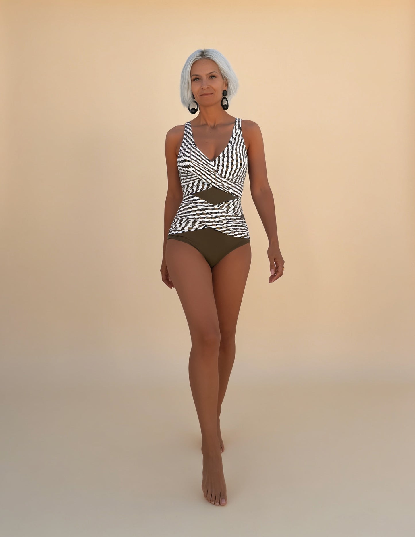 Maillot de bain une pièce motif géométrique sur mannequin, fond beige clair studio
